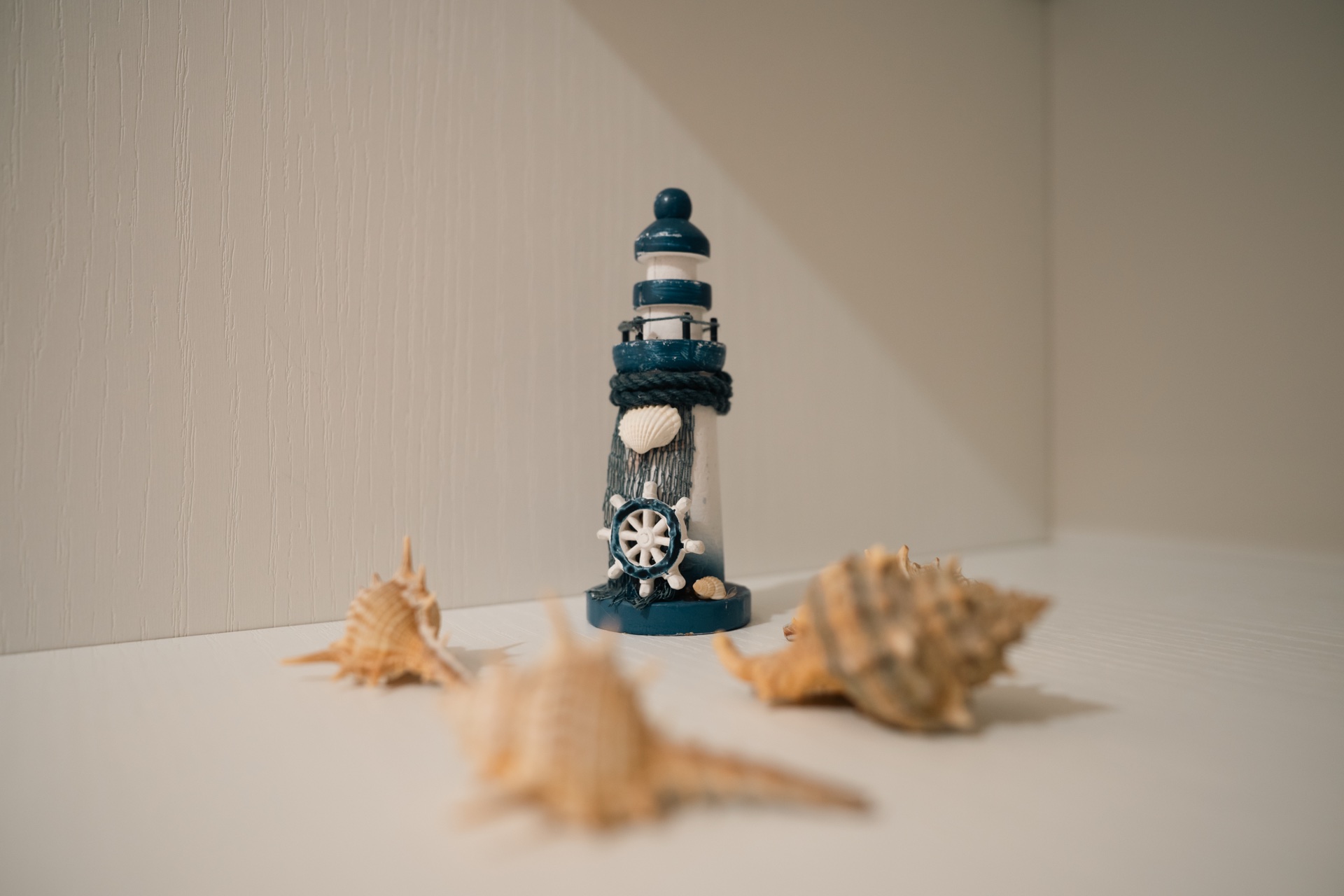 Dettaglio decorativo Holiday Asia — faro e conchiglie